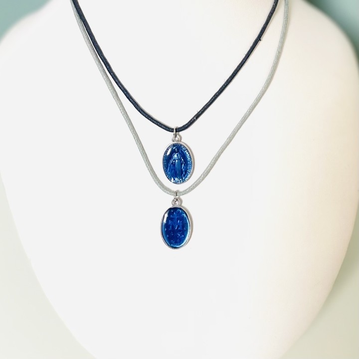 Jolie médaille miraculeuse en résine bleue sur un cordon coton à nouer.