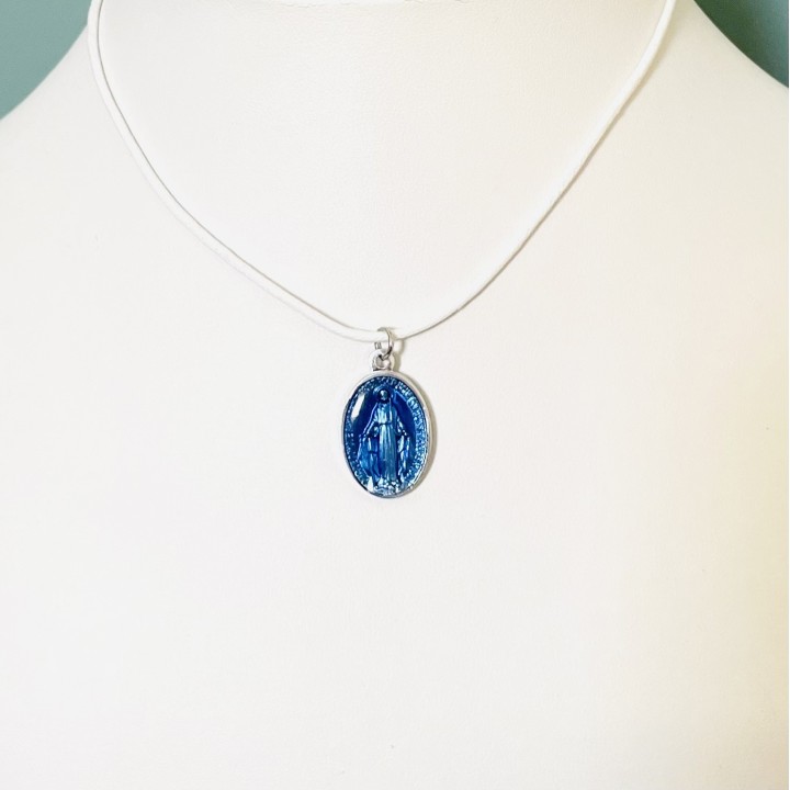 Jolie médaille miraculeuse en résine bleue sur un cordon coton à nouer.